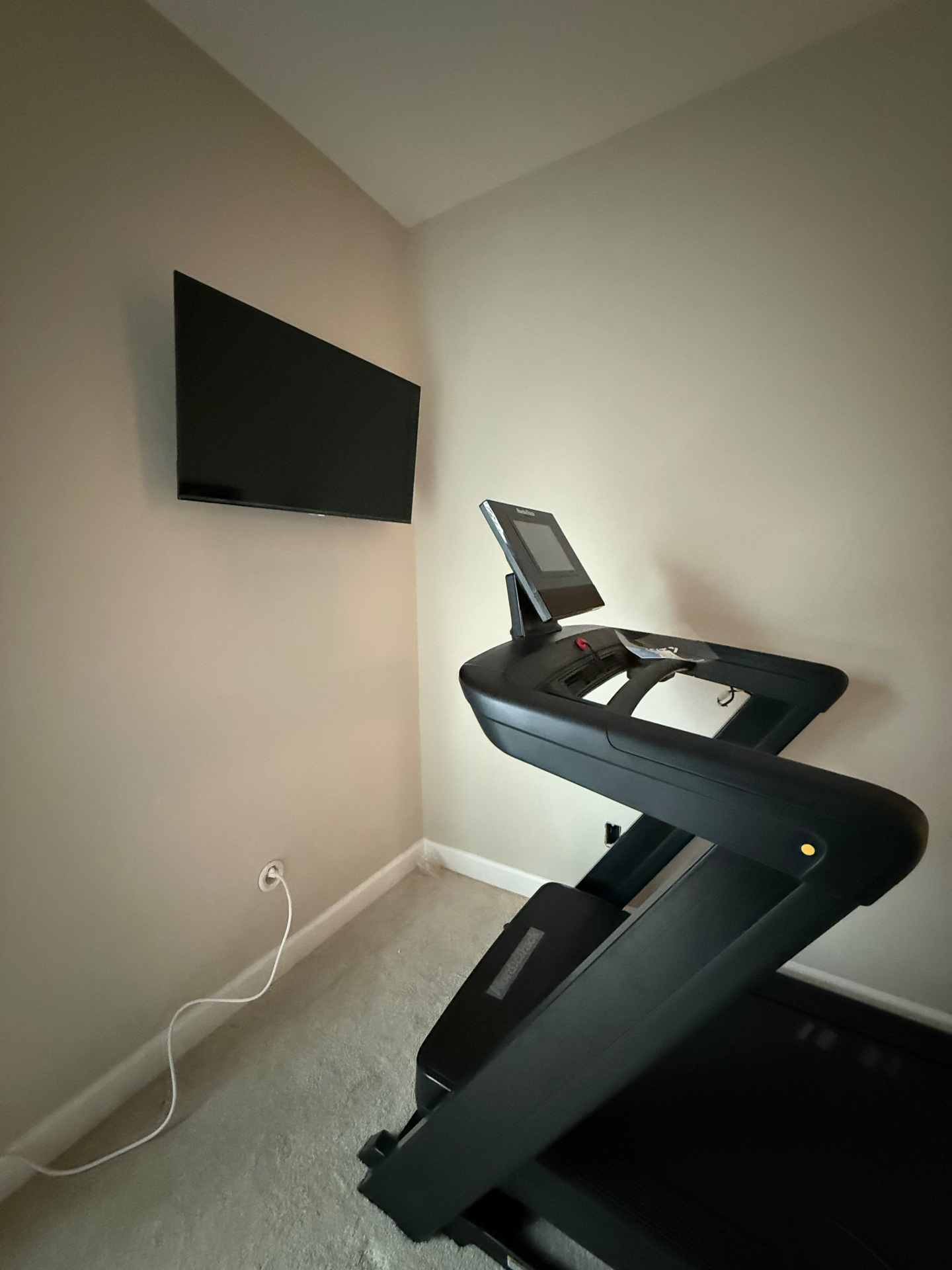 43-inch TV mounted on drywall in Marietta, GA workout room with full-motion mount and in-wall electrical kit