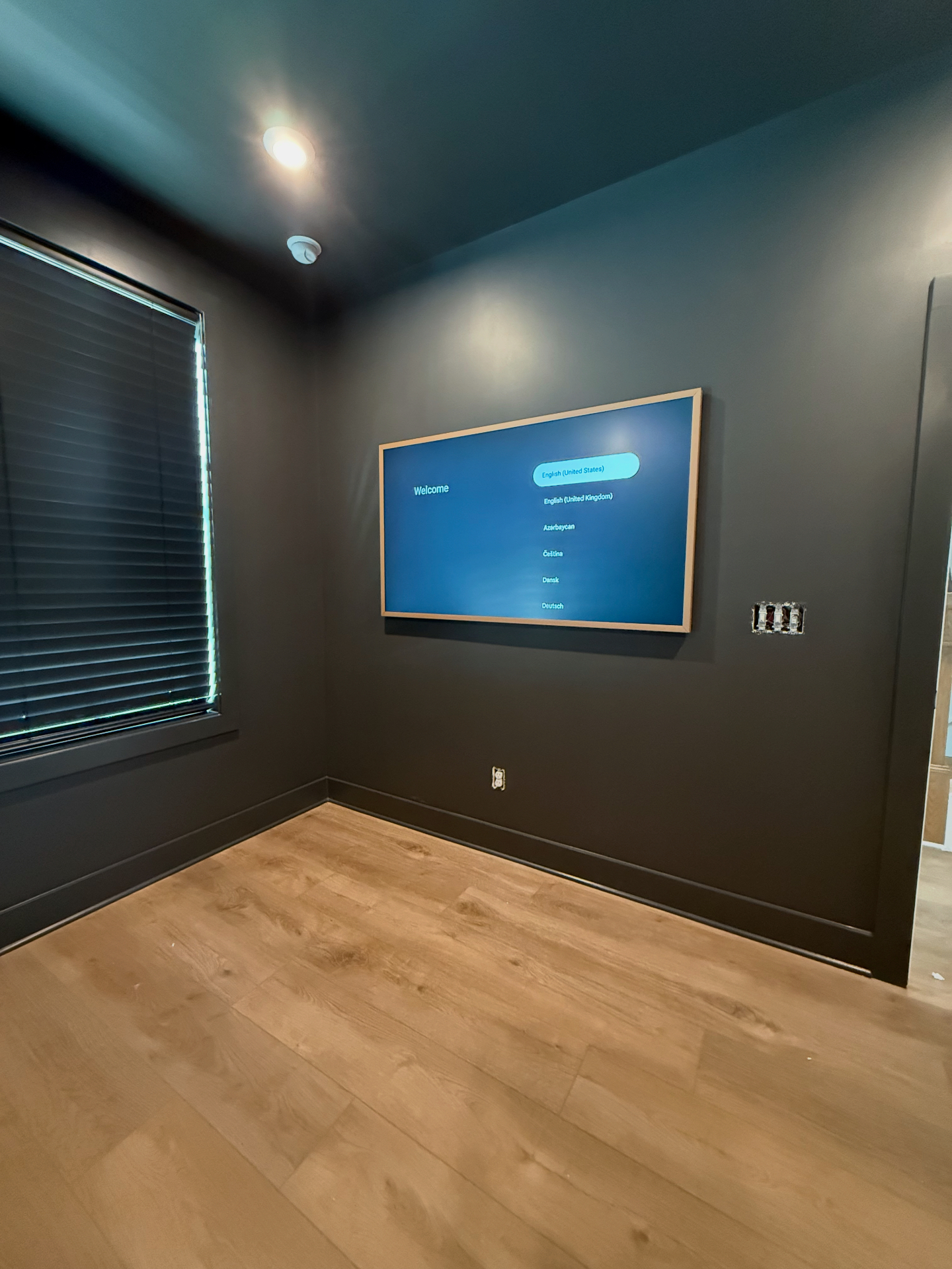 65-inch Hisense Canvas TV flush-mounted on dark accent drywall in Atlanta, GA living room