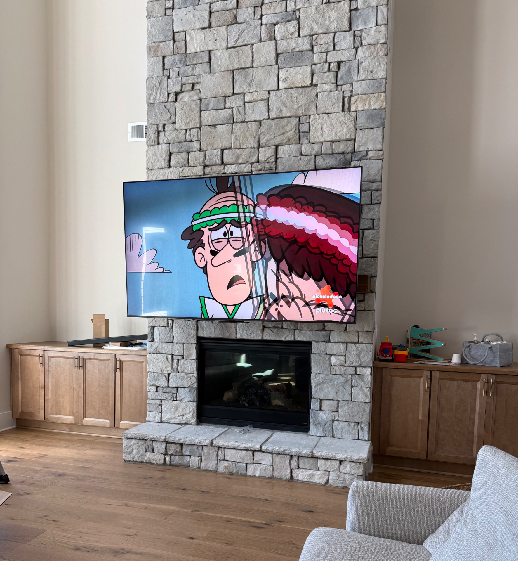 MantelMount TV positioned at eye level on stacked stone fireplace with hidden wires in Atlanta GA