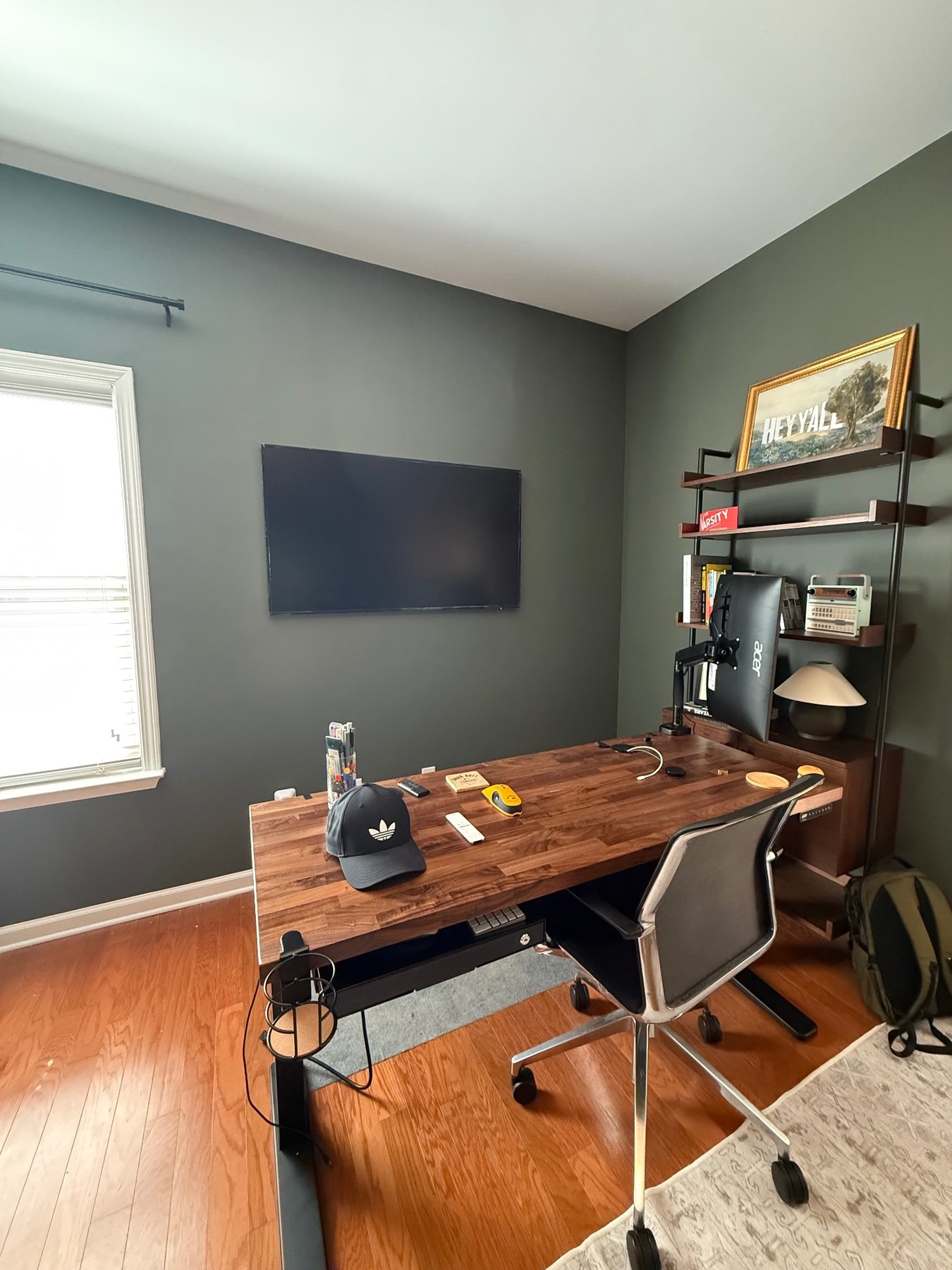 Samsung Frame TV installed on a dark green home office wall with clean cable management