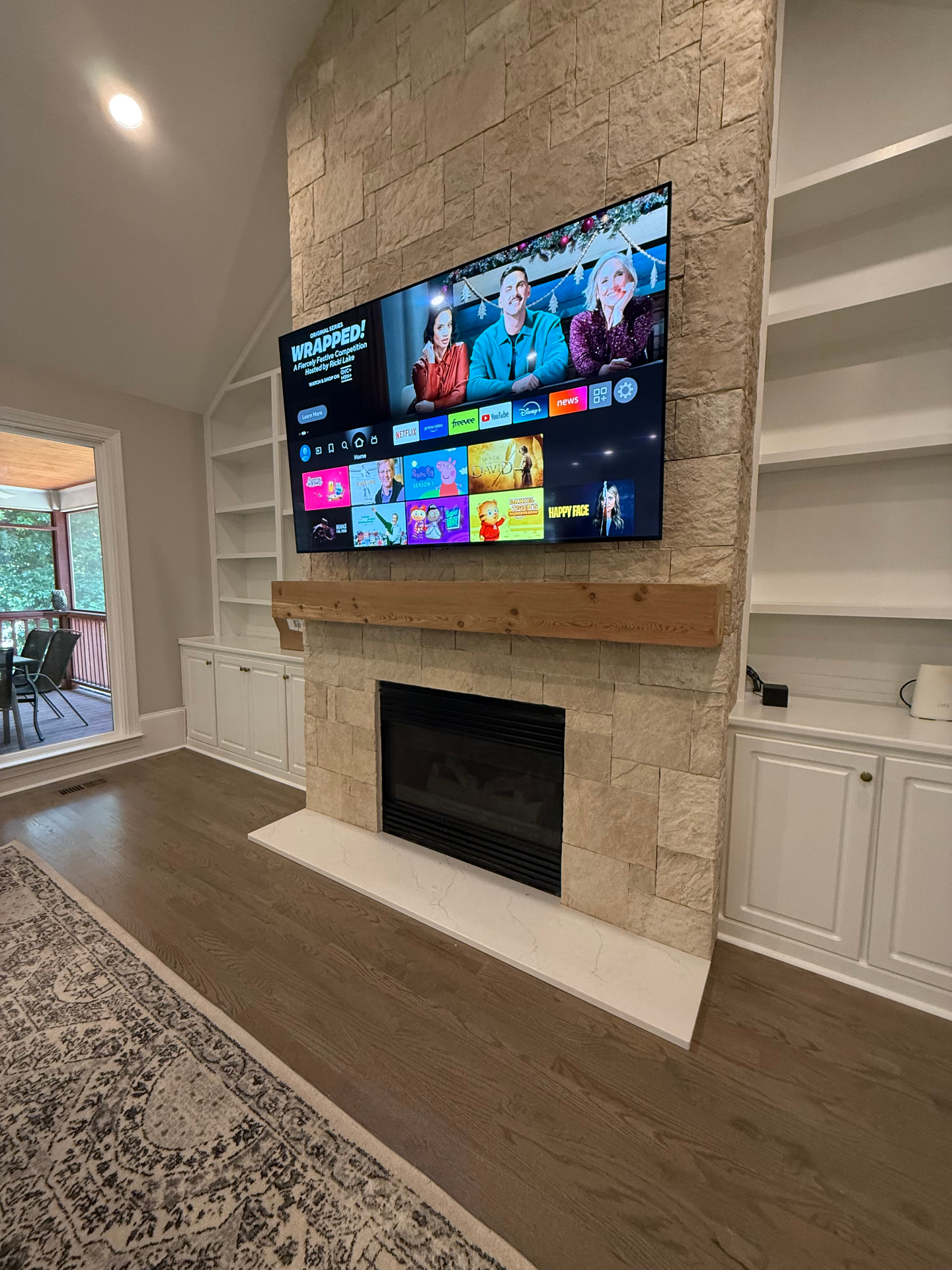 70-inch TV mounted on stone accent wall in Powder Springs, GA with full-motion mount